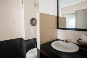 a bathroom with a sink and a toilet and a mirror at Diamond Park Inn Chiangrai & Resort in Chiang Rai