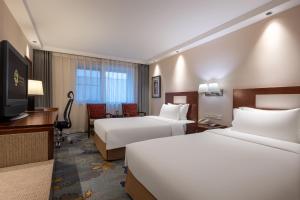 Postel nebo postele na pokoji v ubytování Sunworld Hotel Wangfujing
