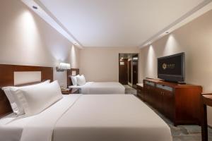 Postel nebo postele na pokoji v ubytování Sunworld Hotel Wangfujing
