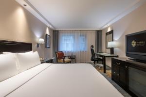 北京市にあるサンワールド ホテル ワンフージンのベッド1台、薄型テレビが備わるホテルルームです。