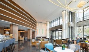 a rendering of a restaurant with tables and chairs at UrCove by Hyatt Tianjin West Railway STN in Tianjin