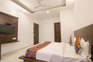 新德里的住宿－FabExpress Ero sky Palace，一间卧室配有一张床和一台平面电视