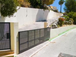 a gate on a wall next to a street at Belvilla by OYO Casa Panorama Altea Hills in Altea la Vieja