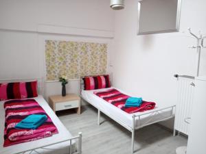 two beds in a room with red and blue blankets at Ferienwohnungen direkt am See mit Einzelnbetten in Waldeck