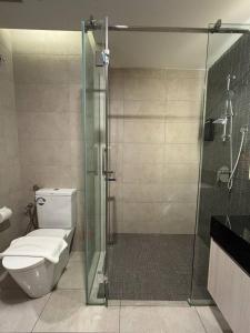 吉隆坡的住宿－Societe by Bamboo Hospitality，一间带卫生间和玻璃淋浴间的浴室