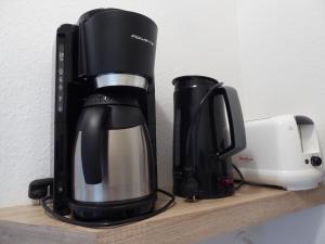 uma cafeteira e uma cafeteira numa prateleira em Ferienwohnung Am Kräutergarten - mit Pool, Sauna und Garage em Missen-Wilhams