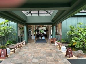 un corridoio di un edificio con panchine e piante di Outrigger Kauai Beach Resort & Spa - Rm 1115 a Lihue