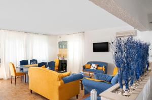 a living room with blue couches and a tv at Milos Inn in Adamantas