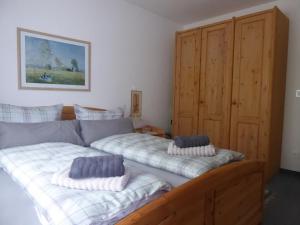 ein Bett mit zwei Kissen auf einem Zimmer in der Unterkunft Ferienwohnung Am Kräutergarten - mit Pool, Sauna und Garage in Missen-Wilhams