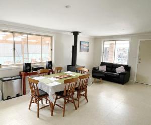 een woonkamer met een tafel en stoelen en een open haard bij Tuncurry tranquility PID -STRA - 59456 in Tuncurry
