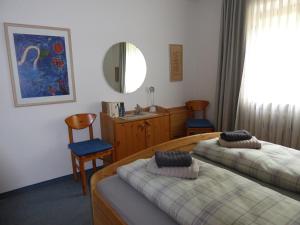 Habitación de hotel con 2 camas y espejo en Ferienwohnung Am Kräutergarten - mit Pool, Sauna und Garage en Missen-Wilhams