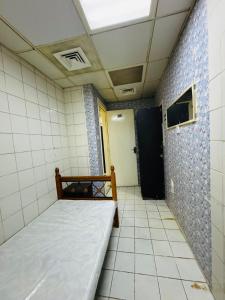Cette petite chambre comprend un lit et une porte. dans l'établissement small room PM new location, à Abu Dhabi