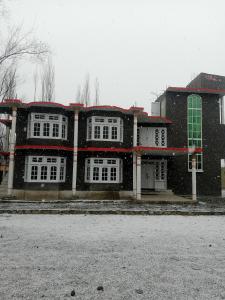 ein großes Gebäude mit weißen Fenstern im Schnee in der Unterkunft Skardu One Resort in Skardu