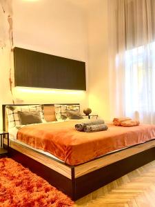 een slaapkamer met een groot bed en een oranje deken bij ORANGE Pearl Apartment 3 rooms near the Danube in Boedapest
