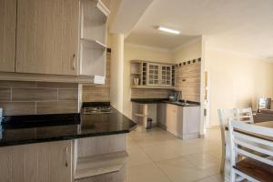 - une cuisine avec des placards en bois et un comptoir dans l'établissement Saints View Resort Unit 11, à Uvongo Beach
