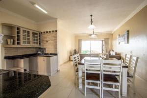 - une cuisine et une salle à manger avec une table et des chaises dans l'établissement Saints View Resort Unit 11, à Uvongo Beach