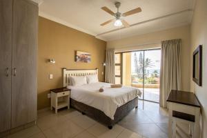 - une chambre avec un lit et un ventilateur de plafond dans l'établissement Saints View Resort Unit 11, à Uvongo Beach