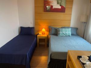 um quarto com 2 camas e uma mesa com um candeeiro em Flat de Luxo Aeroporto Congonhas - Hotel eSuites em São Paulo