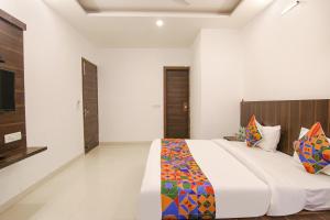 um quarto com uma cama grande e uma televisão em FabExpress Ero sky Palace em Nova Deli