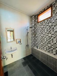 a bathroom with a sink and a tub and a window at Villa Majegau 2 by Deasha in Seminyak