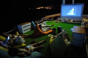 a group of people laying on the floor watching a tv at Leticia Liveaboard in Labuan Bajo