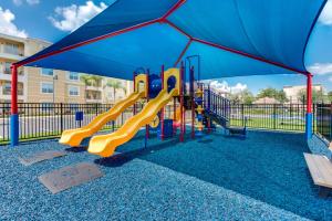 a playground with a slide and an umbrella at Upscale 3BR Condo - Family Resort - Pool And Hot Tub! in Orlando