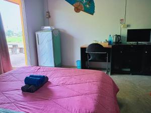 a bedroom with a pink bed with a blue object on it at Six Nature Resort in Chiang Rai