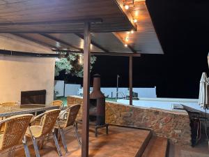 patio ze stołem, krzesłami i kominkiem w obiekcie Casa Rural Quejigo con piscina w mieście Santa Olalla del Cala