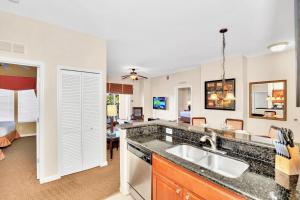 uma cozinha com um lavatório e uma sala de estar em 2BR Resort Suite - Fountain View Private Balcony em Kissimmee