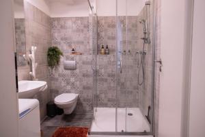 a bathroom with a shower and a toilet and a sink at Loomená Apartments - Free Garage in Košice