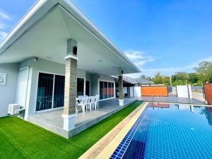 a villa with a swimming pool and a house at Saeng Neua Pool Villa Kaeng Krachan แสงเหนือพูลวิลล่าแก่งกระจาน in Kaeng Krachan