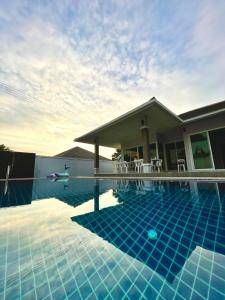 a swimming pool in front of a house at Saeng Neua Pool Villa Kaeng Krachan แสงเหนือพูลวิลล่าแก่งกระจาน in Kaeng Krachan