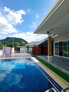 a swimming pool in front of a building at Saeng Neua Pool Villa Kaeng Krachan แสงเหนือพูลวิลล่าแก่งกระจาน in Kaeng Krachan