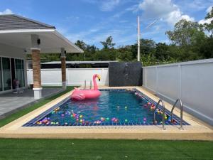 a pool with a pink swan in the water at Saeng Neua Pool Villa Kaeng Krachan แสงเหนือพูลวิลล่าแก่งกระจาน in Kaeng Krachan