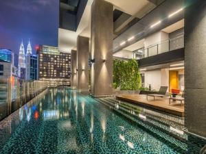 a swimming pool in a building with a city skyline at Anggun Suite KL in Kuala Lumpur