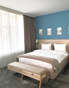 1 dormitorio con 1 cama grande y pared azul en Hotel In City, en Ereván