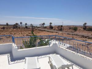 a balcony with chairs and a view of the beach at Villa Yahia Djerba in Bou Menjel