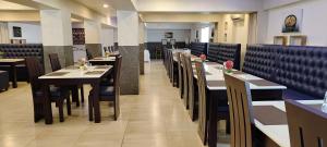 a dining room with tables and chairs in a restaurant at RR INN Group Of Hotels in Kanyakumari