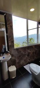 a bathroom with a sink and a toilet and a window at Apart Hotel El Gran Mirador de Palmaire San Gil in San Gil