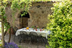een tafel met een wit tafelkleed en stoelen in een tuin bij La Palazzina in Siena