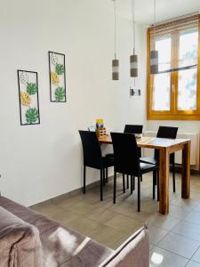 a dining room with a table and black chairs at Agriturismo La Selvaggia in Mandello del Lario