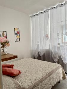 Schlafzimmer mit einem Bett und einem Fenster mit Vorhängen in der Unterkunft Agriturismo La Selvaggia in Mandello del Lario