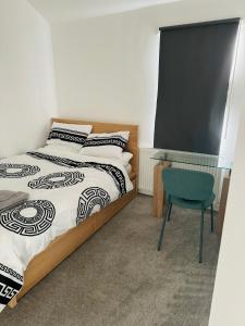 Schlafzimmer mit einem Bett, einem Schreibtisch und einem Stuhl in der Unterkunft City Dreams in Croydon