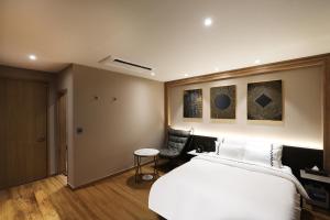 a bedroom with a bed and a table and a chair at Gaeul Hotel in Chungju