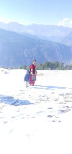 een man en een kind die door de sneeuw lopen bij Tabassum guest house in Kasol