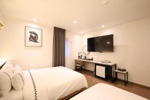 Habitación de hotel con cama y escritorio en Gaeul Hotel en Chungju