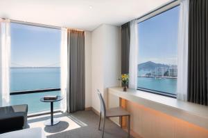 a room with a large window with a view of the water at Hotel Centralbay in Busan