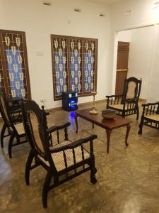 ein Wohnzimmer mit Stühlen und einem Couchtisch in der Unterkunft Holiday Bungalow for rent, Inuvil, Jaffna in Uduvil
