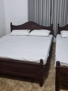 two twin beds in a bedroom withskirts at Holiday Bungalow for rent, Inuvil, Jaffna in Uduvil