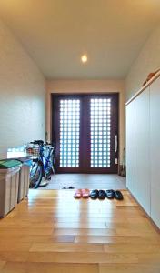 una habitación con zapatos en el suelo frente a una puerta en White House Onsen Guesthouse en Shiraoi